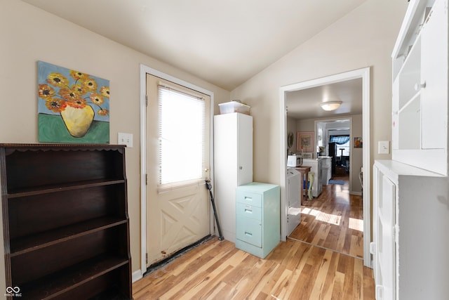 entryway with lofted ceiling, light wood finished floors, and washer / dryer