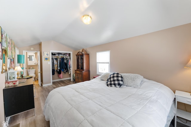 bedroom with lofted ceiling, a closet, baseboards, and light wood-style floors