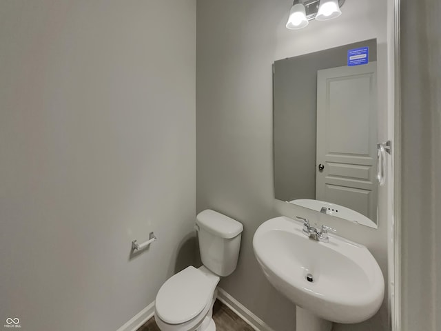 bathroom featuring a sink, toilet, and baseboards