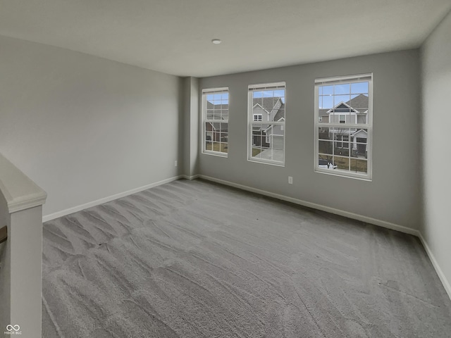 carpeted empty room with baseboards