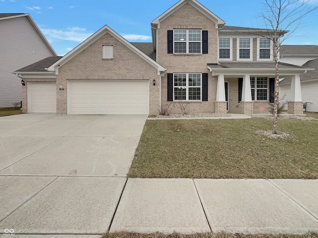 view of front of home with a porch, an attached garage, brick siding, driveway, and a front lawn