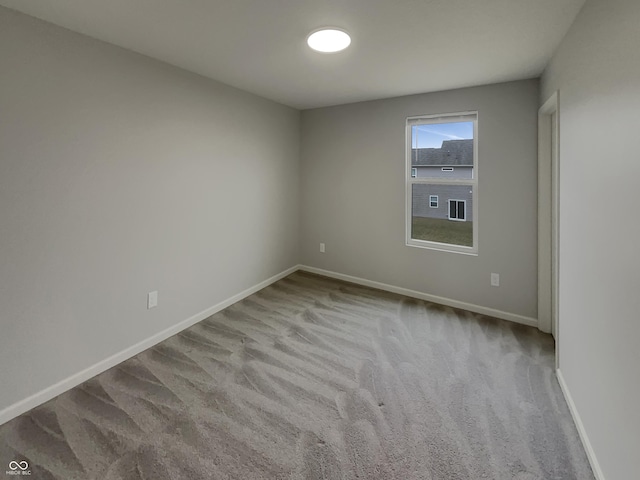 spare room featuring carpet flooring and baseboards