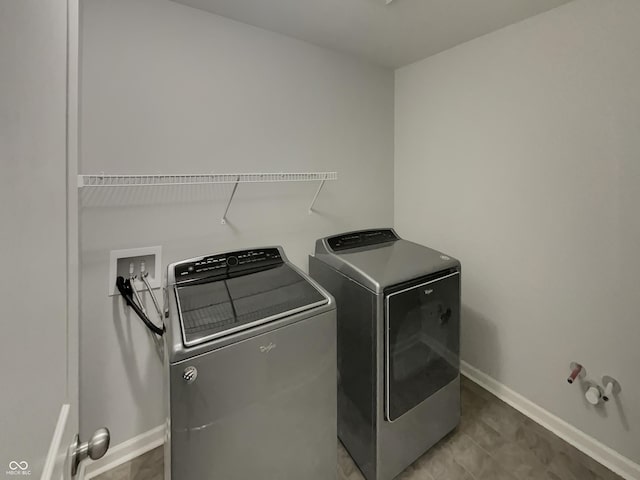 washroom with laundry area, washing machine and dryer, and baseboards