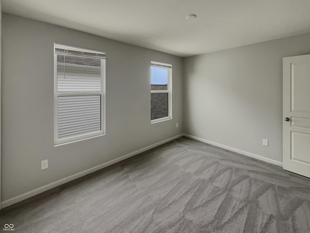 spare room with carpet and baseboards