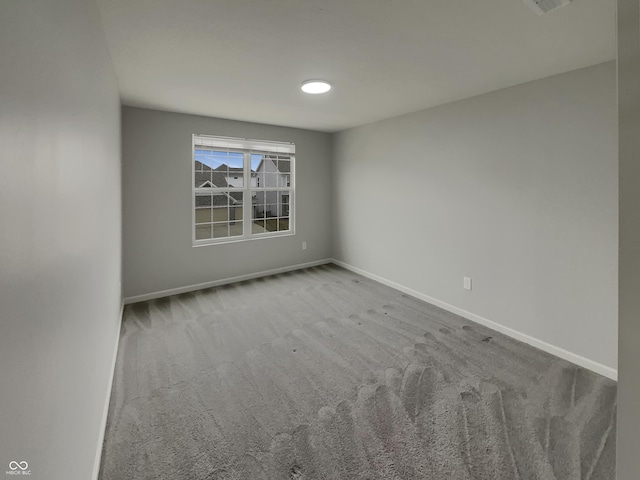 carpeted spare room with baseboards