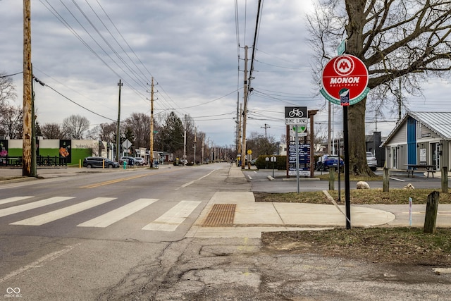 view of street with sidewalks, traffic signs, and curbs