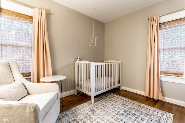 bedroom featuring multiple windows, baseboards, and wood finished floors