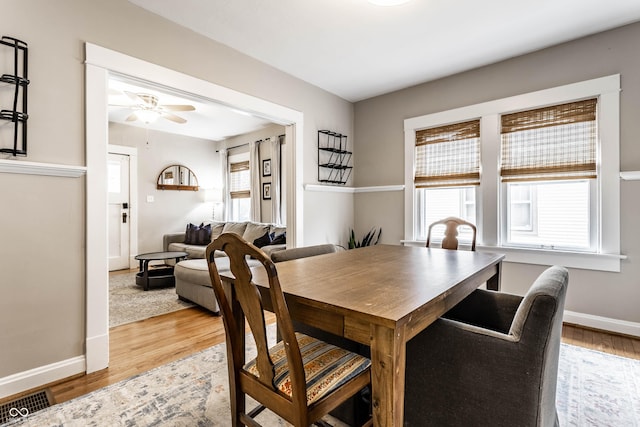 dining area featuring ceiling fan, wood finished floors, visible vents, and baseboards