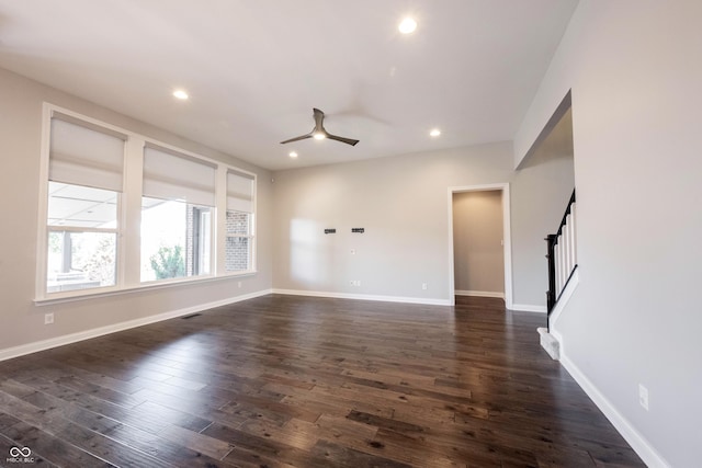 empty room featuring stairs, dark wood-type flooring, visible vents, and recessed lighting