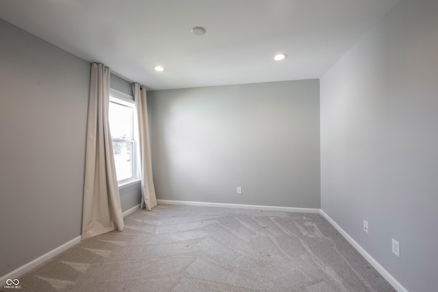 empty room with recessed lighting, light carpet, and baseboards