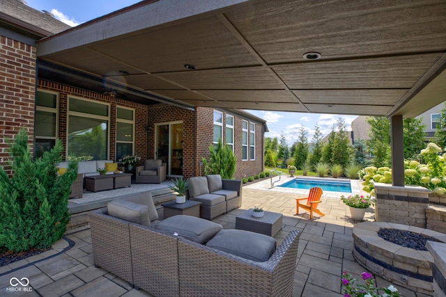 view of patio featuring an outdoor pool and an outdoor living space with a fire pit