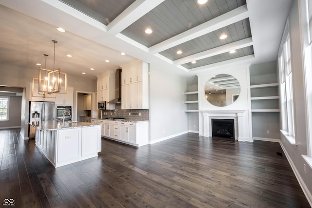 kitchen with a fireplace, white cabinets, open floor plan, appliances with stainless steel finishes, and dark wood-style floors