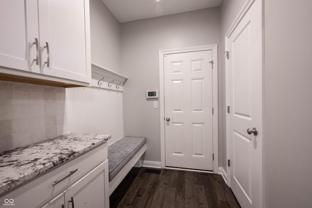 mudroom featuring baseboards and dark wood-style flooring