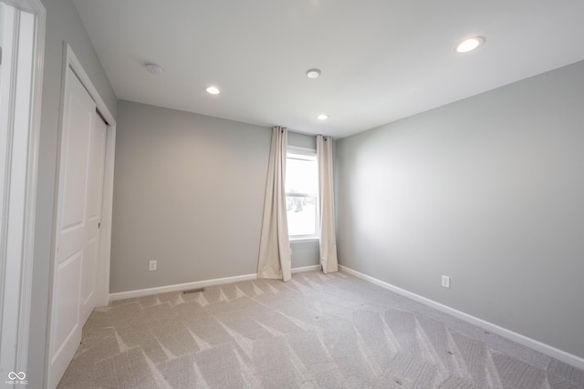 unfurnished bedroom featuring recessed lighting, light colored carpet, and baseboards