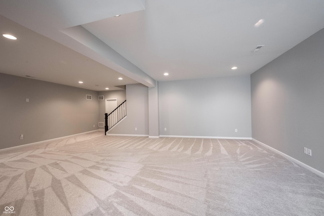 finished basement with recessed lighting, light carpet, baseboards, and stairs