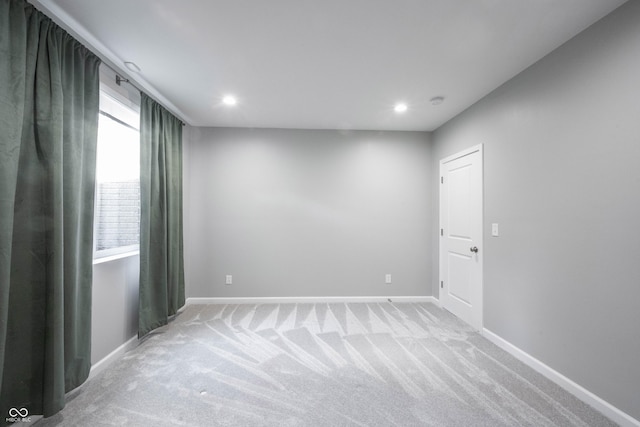 spare room featuring light carpet, baseboards, and recessed lighting