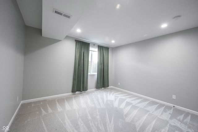 empty room with light carpet, visible vents, baseboards, and recessed lighting