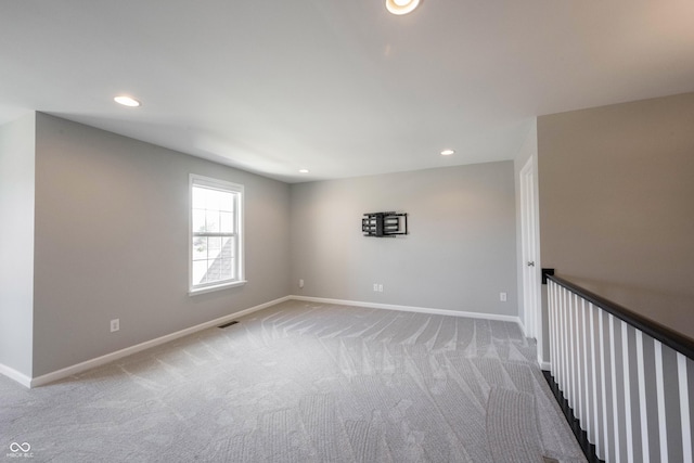 carpeted spare room with baseboards, visible vents, and recessed lighting