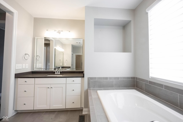 bathroom with visible vents, vanity, and a bath