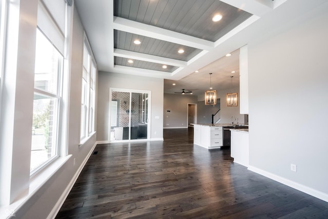 unfurnished living room with dark wood-type flooring, beamed ceiling, recessed lighting, and baseboards