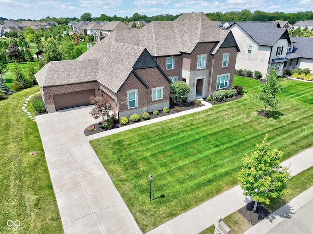 view of front facade featuring a residential view, brick siding, an attached garage, and a front yard