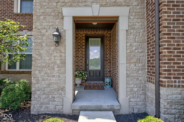 property entrance with stone siding and brick siding