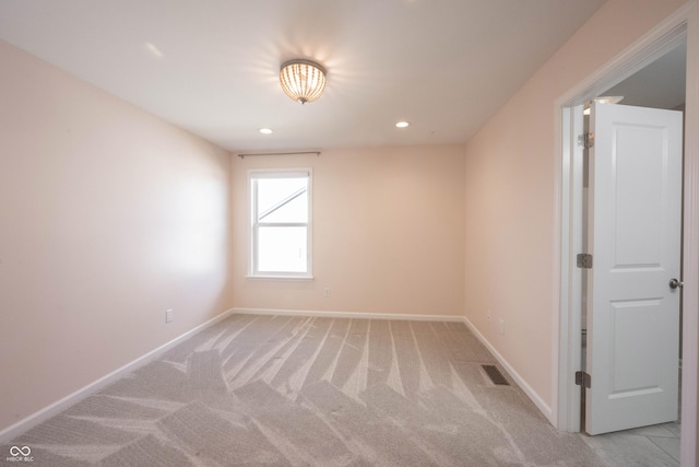 empty room featuring light carpet, recessed lighting, visible vents, and baseboards