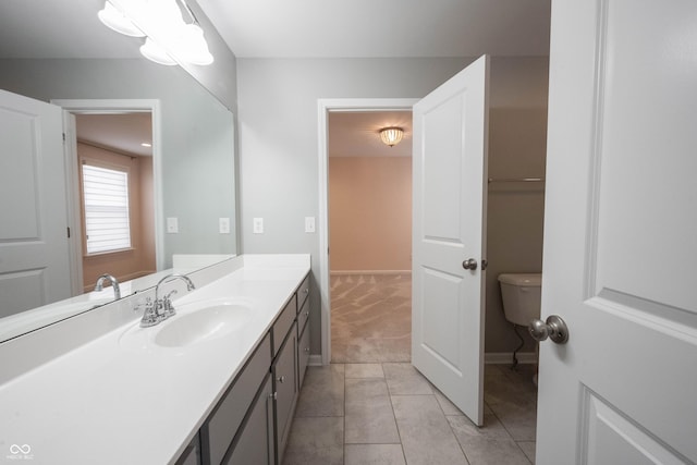 bathroom with tile patterned flooring, toilet, vanity, and baseboards