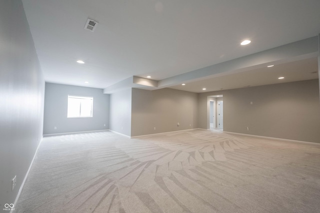 spare room with recessed lighting, light carpet, visible vents, and baseboards