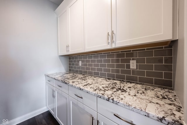 interior details featuring baseboards, wood finished floors, and decorative backsplash