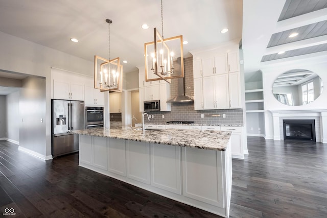 kitchen featuring stainless steel appliances, dark wood finished floors, a glass covered fireplace, and white cabinetry