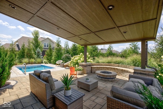 view of patio / terrace with a fenced in pool and an outdoor living space with a fire pit