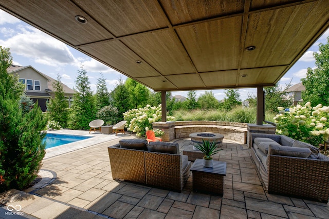 view of patio featuring an outdoor living space with a fire pit and an outdoor pool