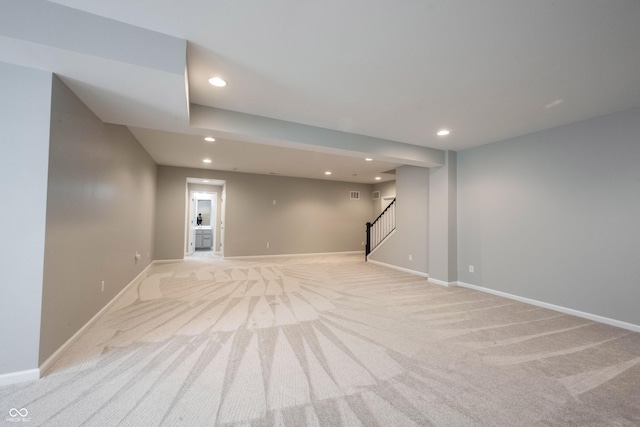 finished basement with baseboards, stairway, light carpet, and recessed lighting