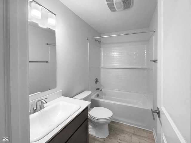 bathroom with visible vents, toilet, vanity, wood finished floors, and  shower combination