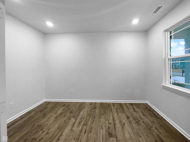 spare room featuring dark wood-type flooring, recessed lighting, visible vents, and baseboards