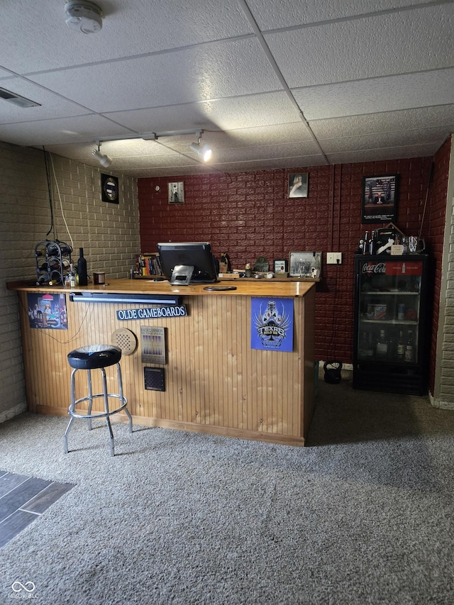 bar with carpet, a dry bar, visible vents, brick wall, and a drop ceiling