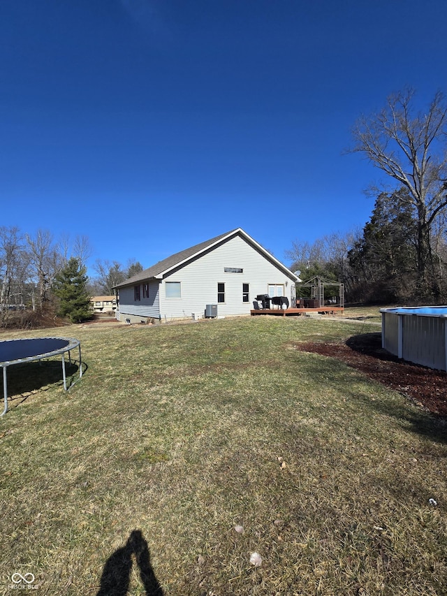 view of yard featuring a trampoline and an outdoor pool