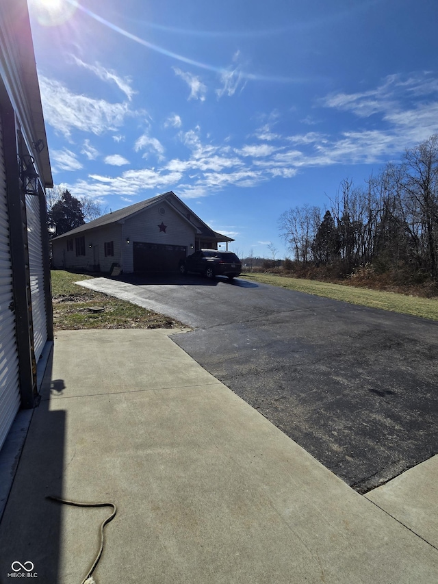 view of side of home featuring driveway and a garage