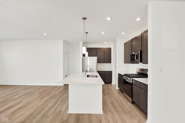19714 Highclere Ln, Sheridan, IN 46069 - kitchen featuring appliances with stainless steel finishes, tasteful backsplash, a sink, light countertops, and light wood-style flooring