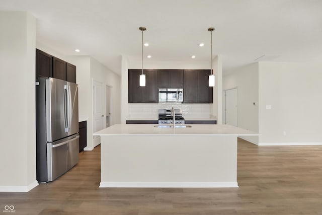 19714 Highclere Ln, Sheridan, IN 46069 - kitchen featuring dark brown cabinets, appliances with stainless steel finishes, a sink, light wood-type flooring, and backsplash