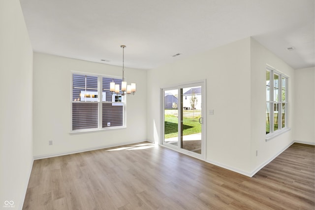 19714 Highclere Ln, Sheridan, IN 46069 - unfurnished dining area featuring light wood-type flooring, a notable chandelier, and a healthy amount of sunlight