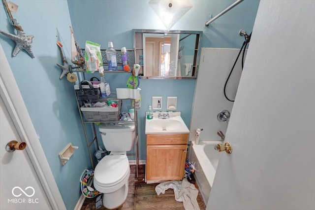 full bathroom with shower / washtub combination, toilet, vanity, wood finished floors, and baseboards