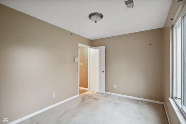 unfurnished room with baseboards, visible vents, and light colored carpet