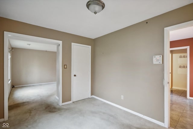 unfurnished bedroom featuring light carpet and baseboards