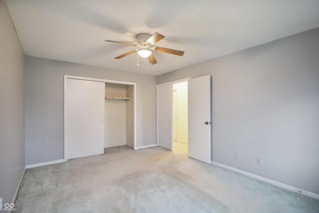 unfurnished bedroom with a closet, light carpet, ceiling fan, and baseboards