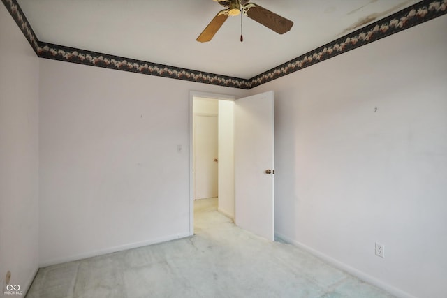 unfurnished room featuring a ceiling fan, light carpet, and baseboards