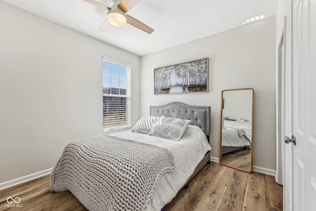 bedroom featuring ceiling fan, baseboards, and wood finished floors