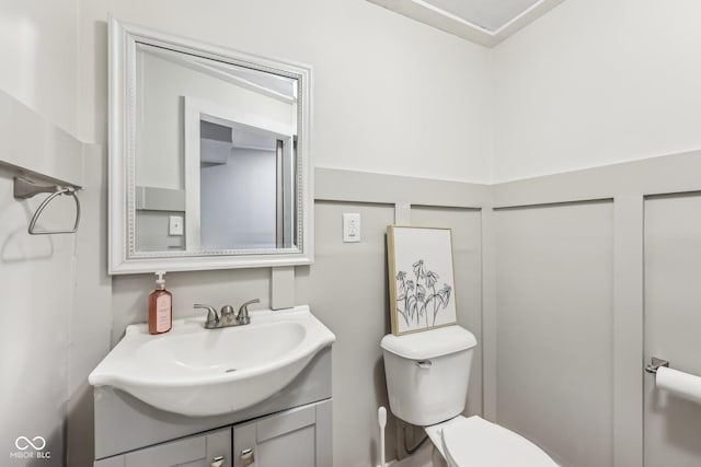 half bathroom with vanity and toilet