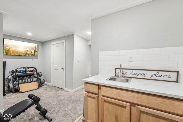 interior space with baseboards, a sink, and light colored carpet